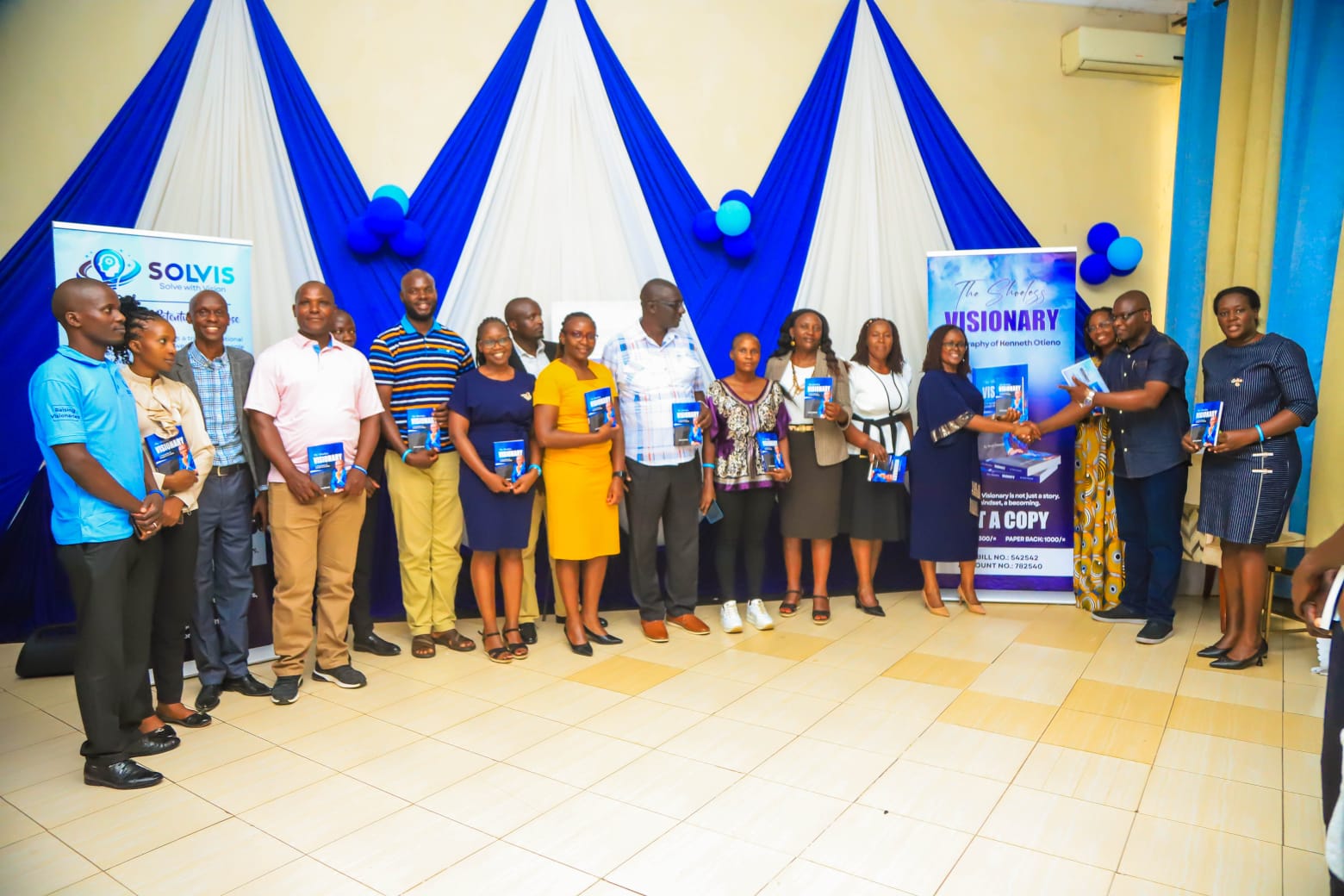 Chief Guest Dr Jackline Mosinya Nyaberi with other guests congratulates Kenneth at the launch event in Kisumu City venue