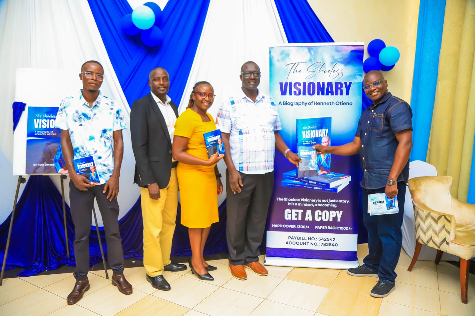 Kenneth hands a copy of the book to Prof Charles Nyambuga during the official launch event held in Kisumu City venue